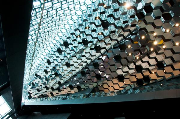 HARPA Music Hall and Conference Center in Reykjavik features aesthetic elements throughout the building such as hexagonal mirrors on the ceiling and a glass facade representing the Icelandic basalt rock formations.