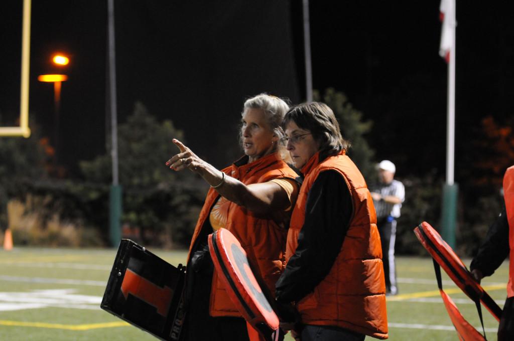 Deanna Bower teaches prospective chain chick Cindy Bloch the logistics of running the chain. 14 years ago, Bower founded the chain chicks, a group of women who voluntarily runs the chain in high school and junior college football games. 