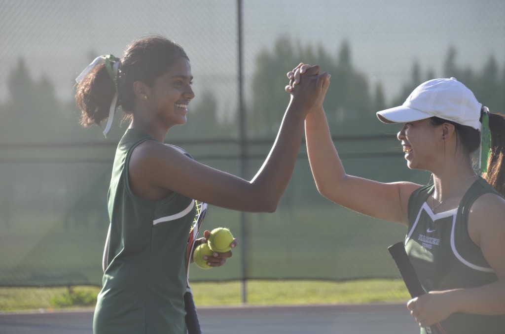 Arden Hu (10) and Sahithya Prakash (11) high-five each other after winning their doubles match 2-0. Despite their win, the team lost the match against Menlo, setting the overall record to 6-1. 