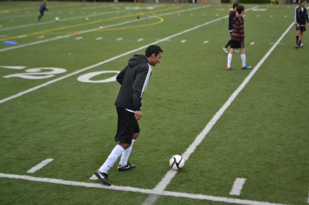 Varsity team captain Simar Mangat (12) kicks a soccer ball during practice. The Varsity team plays its first game on November 20 against Saratoga High School.