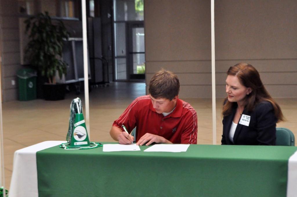 Donning a Stanford shirt, Maverick signs his Letter of Intent with his mother. Maverick is excited about the prospect of golfing at a Division 1 school.