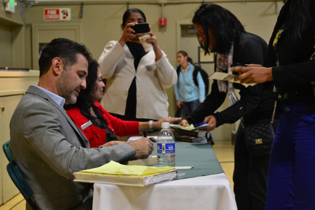 Internationally+renowned+author+and+philanthropist+Khaled+Hosseini+signs+books+after+the+Speaker+Series+event.+The+line+of+people+anxiously+awaiting+to+meet+Hosseini+spanned+the+length+of+the+gym.