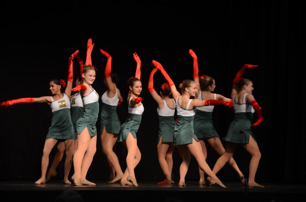 The Varsity dance team, including Ria Desai (12), Darby Millard (10), Erika Olsen (10), and Michaela Kastelman (12), perform at the annual holiday show. The assembly highlighted several performing arts groups from all three campuses.
