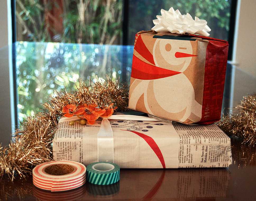 Old newspaper and brown paper shopping bags are a great way to reuse everyday materials as a form of gift-wrapping. A Starbucks “Rekindle” bag and a Tiffany & Co. advertisement from the Wall Street Journal are fashioned into packaging material, ornamented with ribbons, tape, and bows.