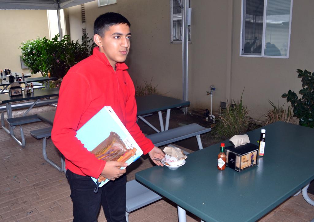 Sophomore Neil Chitkara picks up his trash as he leaves lunch. He is one of many students who have taken the student councils presentation about cleaning the lunch area to heart.