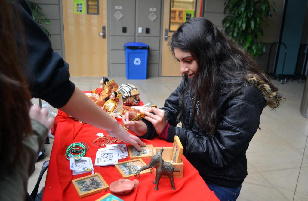 Senior Sarina Vij designs traditional Indian Henna tattoos for students as she hosts a booth for India at Global Empowerment and Outreach clubs annual Multicultural Carnival. The carnival was held Wednesday, March 20 in the Nichols atrium. 