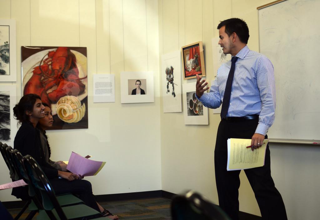 College Counselor Kevin Lum Lung speaks with Preeya Mehta (12) before the start of class. The seniors met with their college counseling classes for the last time on Tuesday, March 26.