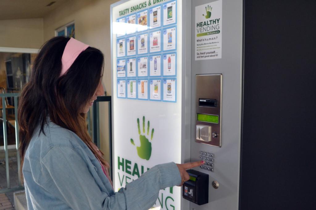 Freshman Eesha Chona exchanges money for healthy snacks at the vending machine. Located near the barbecue grill, the machine contains energy bars, drinks, wraps, and more for anywhere from 75 cents to $2.