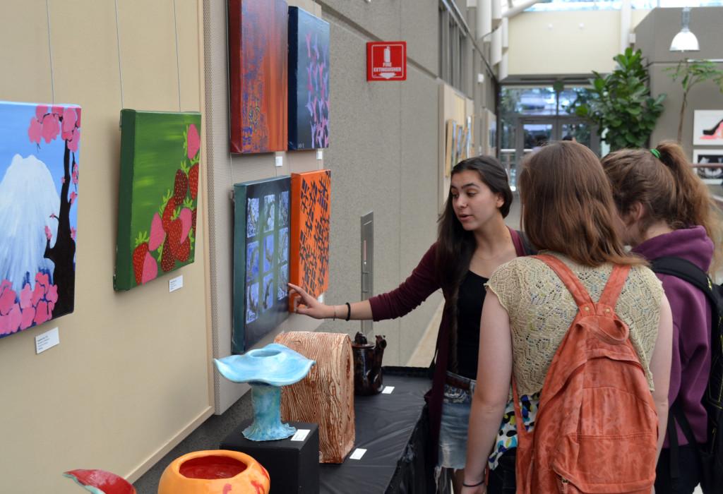 Senior Jazzy Gill explains her artwork to other students at the annual Art Exhibition. During long lunch on Wednesday, May 1, during long lunch, students got the opportunity to view more than 150 of their peers’ artistic creations.