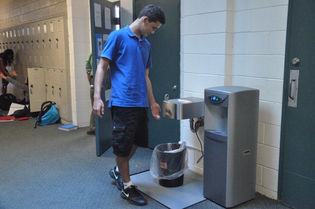 Evan Lohn (10) disposes of trash near the water bottle fill station in Main Hall. The announcement made by the Harker Green Committee specifies exactly which type of wastes belong in the trash and which to be recycled.