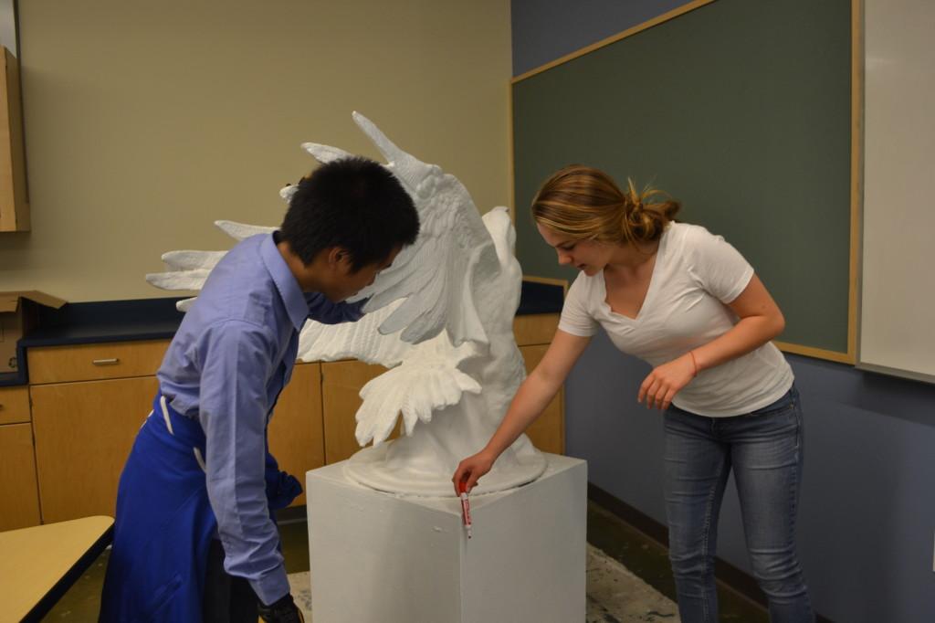 Sarah Bean (11) and Michael Lin (11) discuss the plans for the junior class’ eagle at a meeting today in Dr. Miriam Allersma’s classroom. They chose the theme reality tv to style and design their eagle with.  