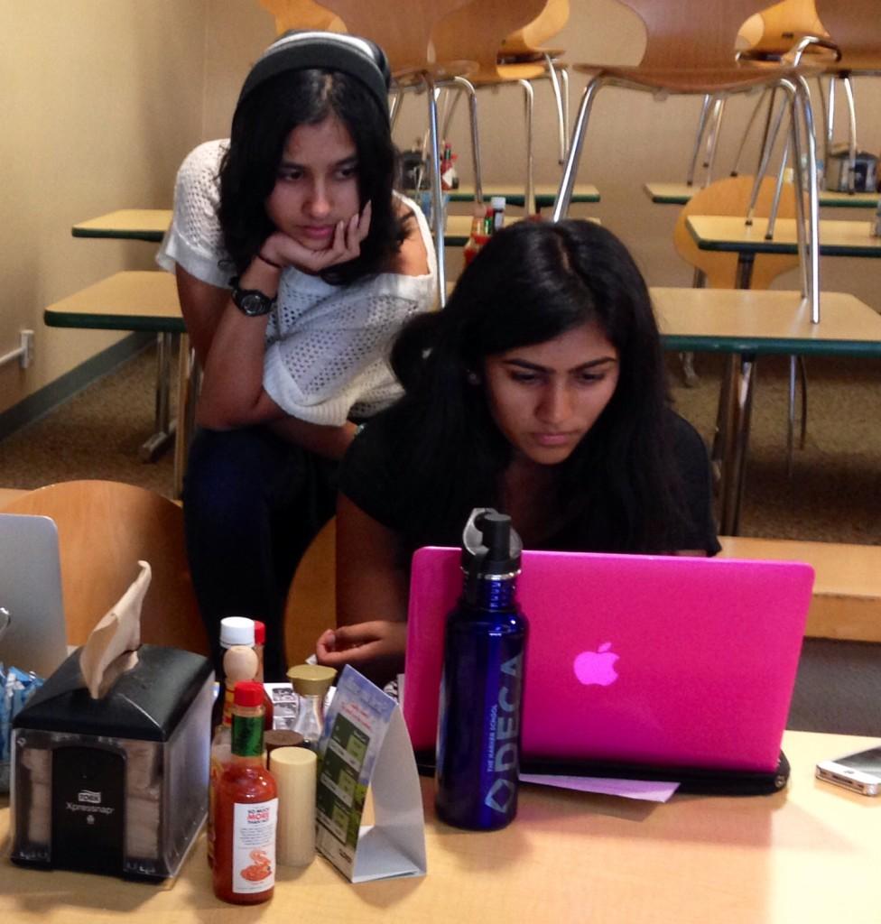 DECA members Neymika Jain (9) and Riya Chandra (9) look through examples of business plans at the DECA study session yesterday while trying to formulate ideas for their own. They are preparing for when they will have to present their ideas at competitive DECA conferences.