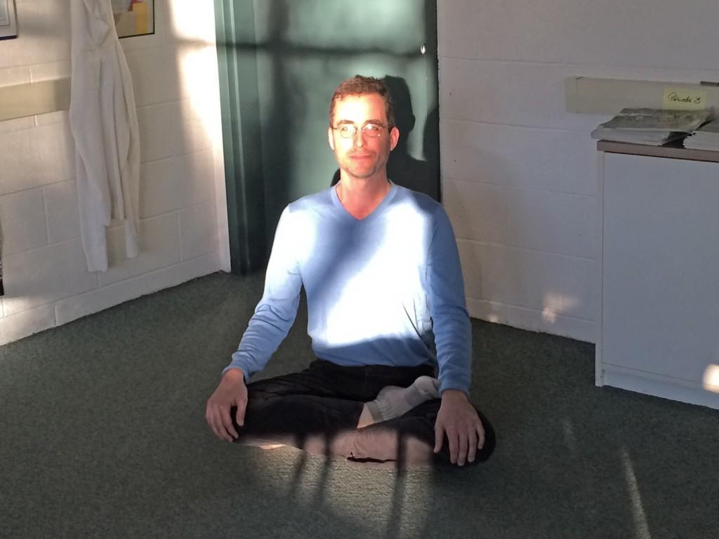 Nicholas Manjoine demonstrates the Ardha Padmasana, or half lotus pose, where the left leg is placed on top of the right leg in a crossed position. He currently teaches yoga after school on Tuesdays and Thursdays. 