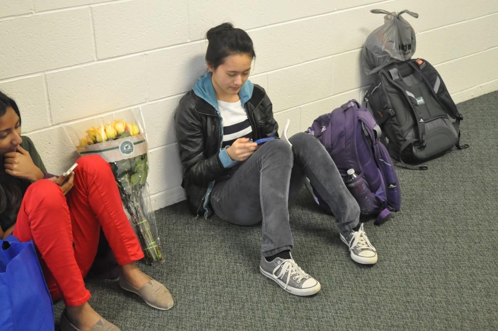 Junior Helen Wu uses her phone in Main Hall after school. Main Hall is a popular hangout location for students. 