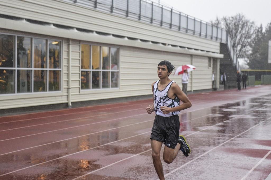 Junior Rahul Balakrishnan runs his race in pouring rain during the Archbishop Mitty Invitational on Wednesday afternoon. This invitational is the first meet of the Track and Field season.  