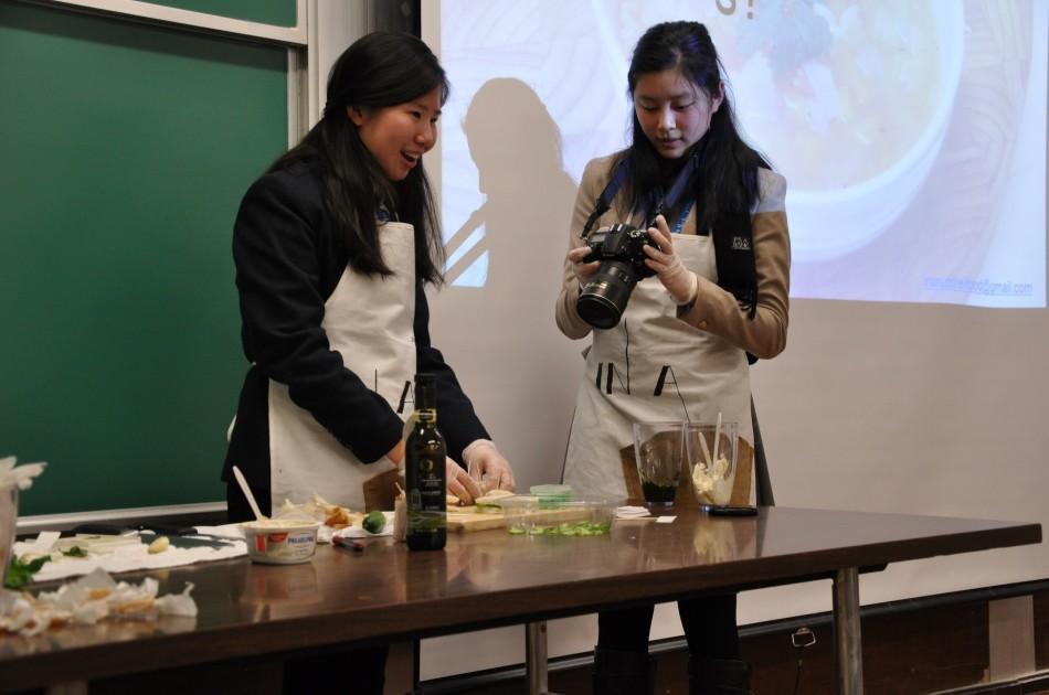 Junior Priscilla Pan arranges samples of tea-sandwiches created in front of a live audience while Jessica Chang (11) instructs on how to get the best angles for cooking footage. The pair gave a presentation at the CSPA convention in New York on how to maintain a presence in food blogging online for high school publications.