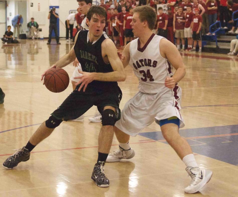 Huck Vaughan (12) dribbles the ball around his opponent. The boys placed 2nd in CCS after losing against Sacred Heart 48-37.