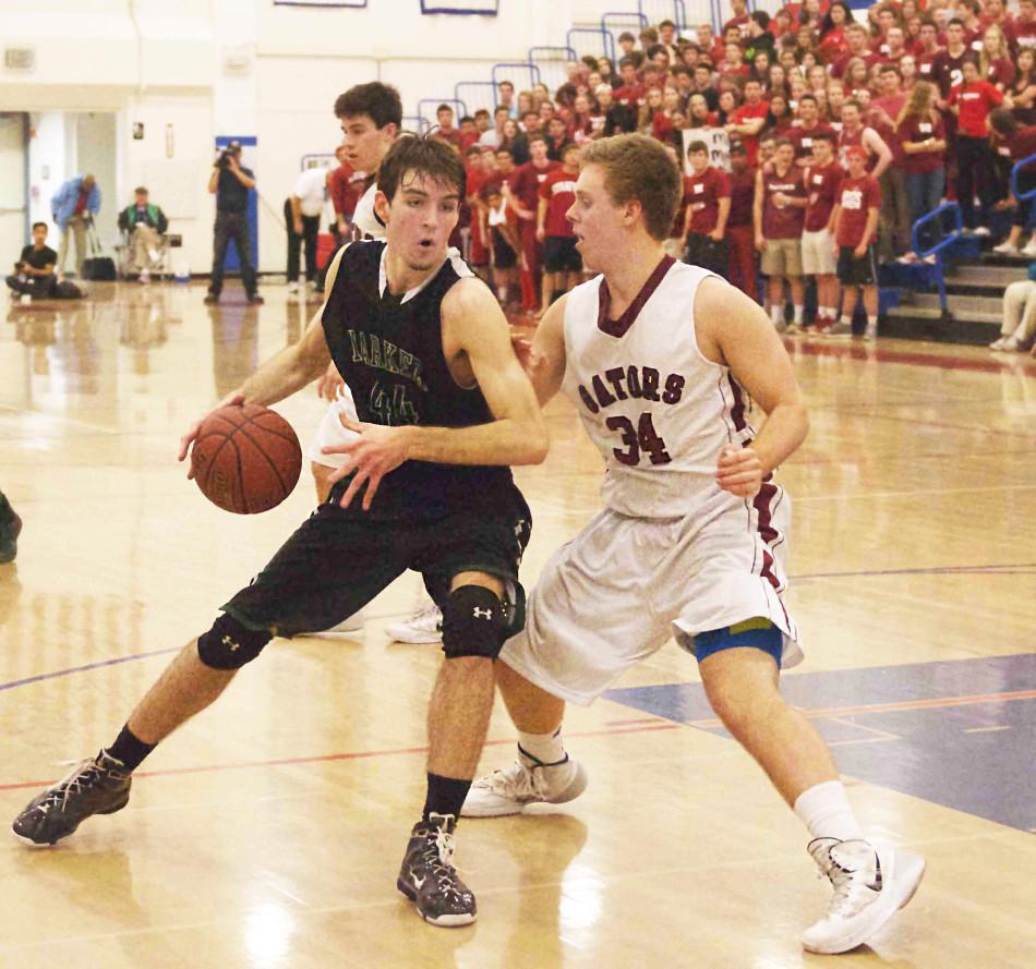 Huck Vaughn (12) dribbles the ball around his opponent. The boys placed 2nd in CCS after losing against Sacred Heart 48-37.