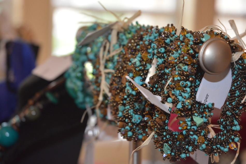 Turquoise beaded bracelets hang from a silver poll. By vending goods like these, the home party was able to raise more than $4,500.​