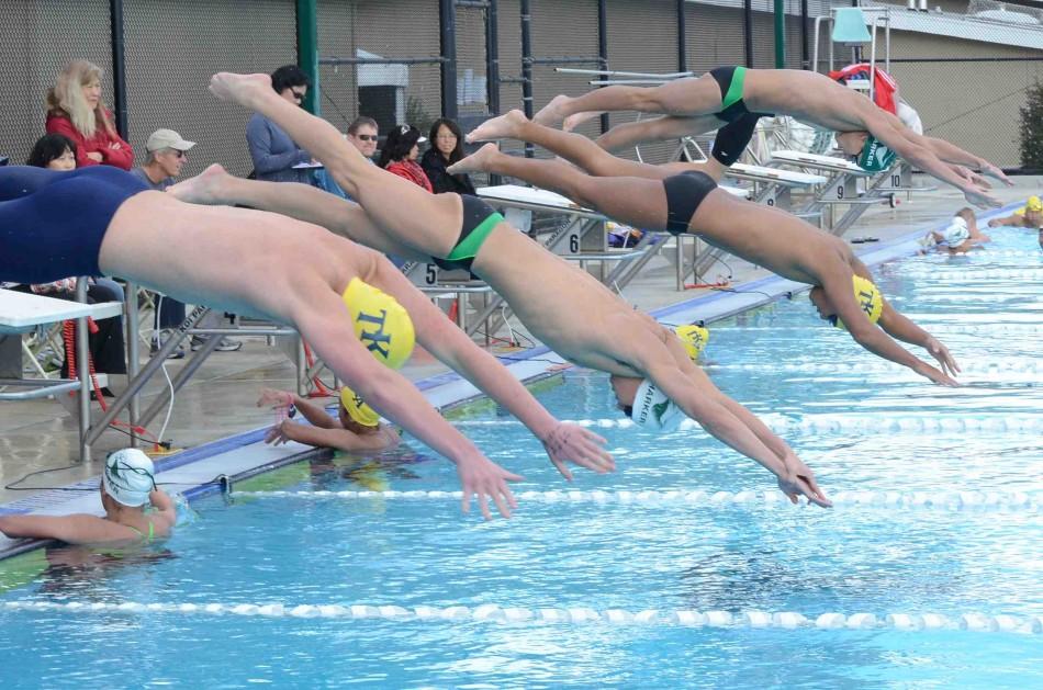 Boys varsity swimmers start off their events with a dive in their meet against Kings Academy. Swimming is one of eight varsity spring sports. 