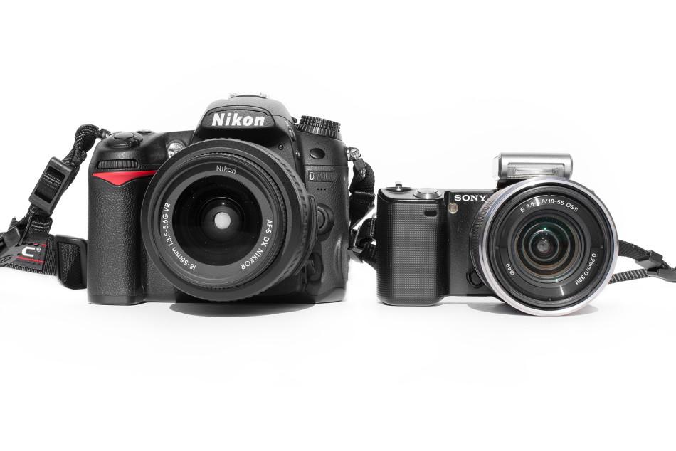 Despite the DSLR on the left being much larger and double the price, youd be wrong if you thought it yields higher quality images than the mirrorless camera on the right. Each camera has their respective manufacturers 18-55mm f/3.5-f/5.6 standard zoom lens mounted.
