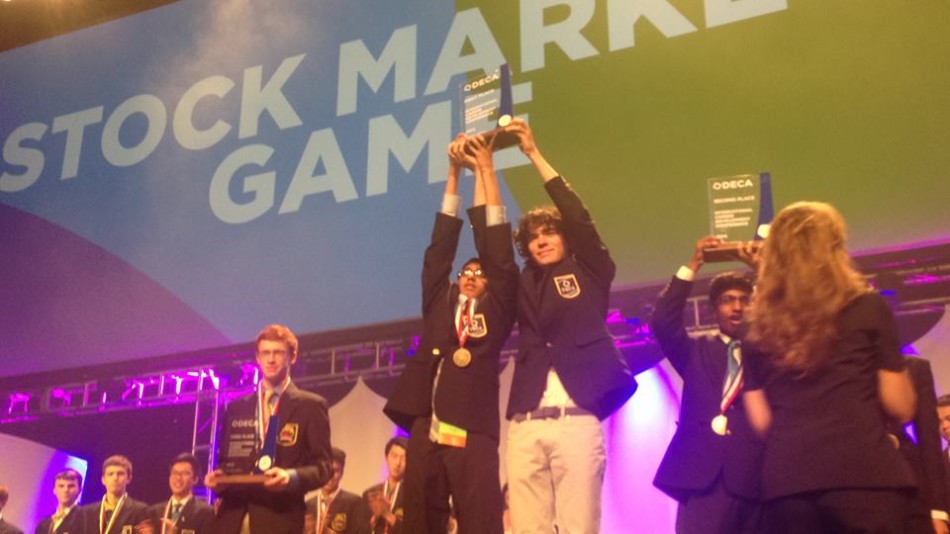 DOWN TO BUSINESS: Nihal Uppugunduri (12) and Alex Tuharsky (11) won first place in the Stock Market Game this year. They accepted their prize recently in Atlanta at DECAs international conference. 