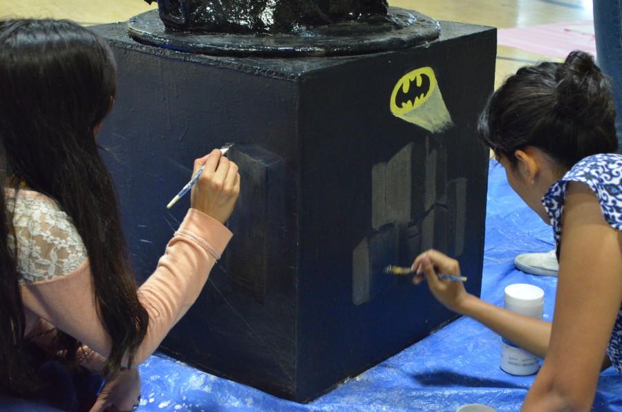 Two seniors work on their eagle. The senior’s homecoming theme this year is Batman, causing them to make the eagle mainly black. 