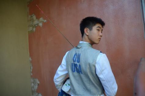 Darren Gu (9) poses in his fencing uniform. He first began fencing in the fourth grade.