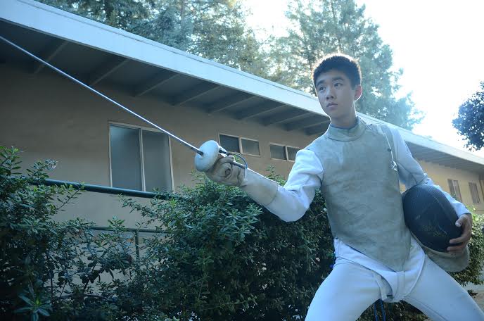 Freshman Darren Gu lunges forward with his foil. The foils have blunt ends, as well as wiring to detect impact. His uniform also consists of a helmet. 