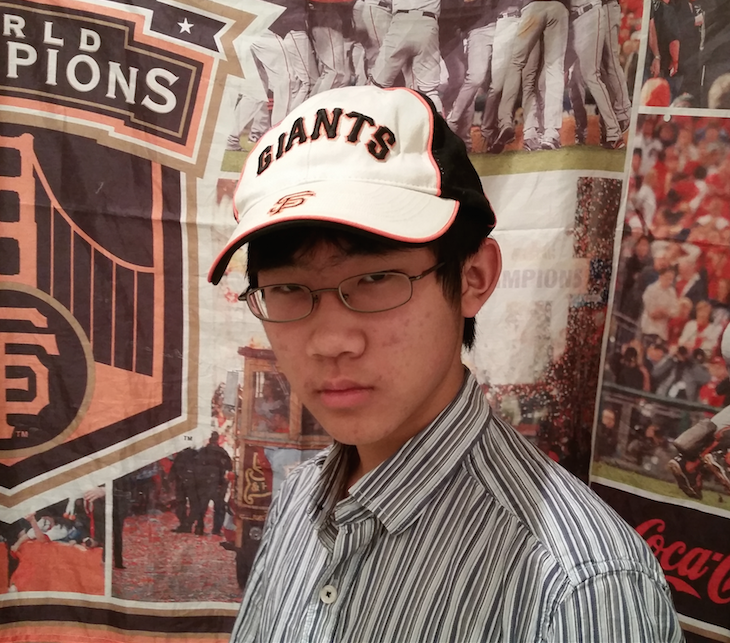 Derek Yen (9) wears a baseball cap in support of the San Francisco Giants. The Giants won the World Series by defeating the Kansas City Royals in Game 7.