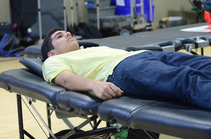 Glenn Reddy (12) waits for his blood to be drawn by an American Red Cross volunteer. The Red Cross club partnered with the Red Cross to host the blood drive. 
