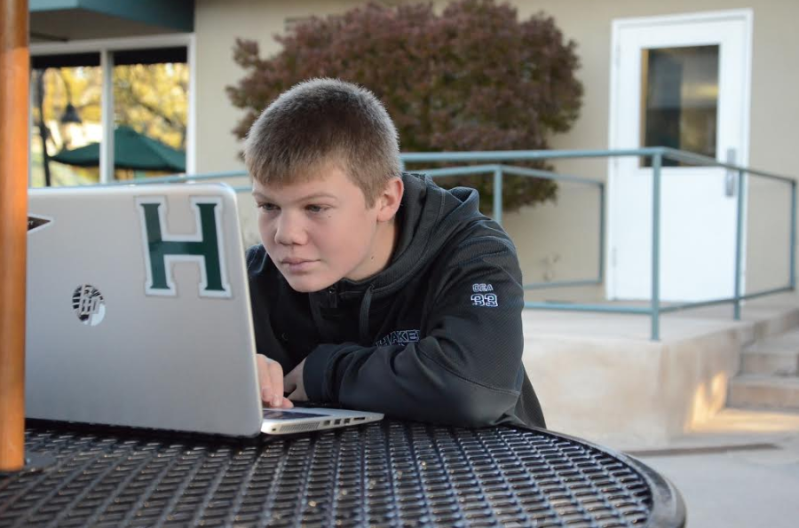 Freshman Dominic Cea finishes his homework on his laptop. The first semester was challenging for many freshman, as they werent used to the difficulty of high school academics.
