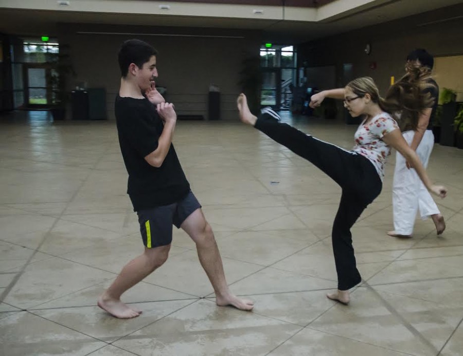 Annabella Armstrong (10) aims a front outwards kick at Jonathan Hochberg (11). The two attend capoeira classes conducted in Nichols Hall on Monday, Wednesday and Thursday.