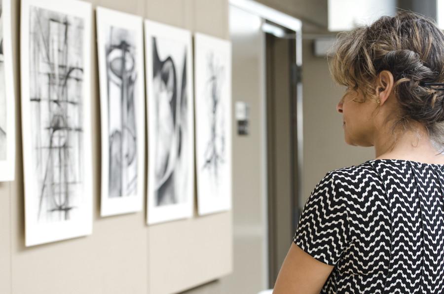 Mathematics teacher Lola Muldrew looks over abstract drawings featured during the APSA exhibition. The exhibition began during long lunch yesterday.