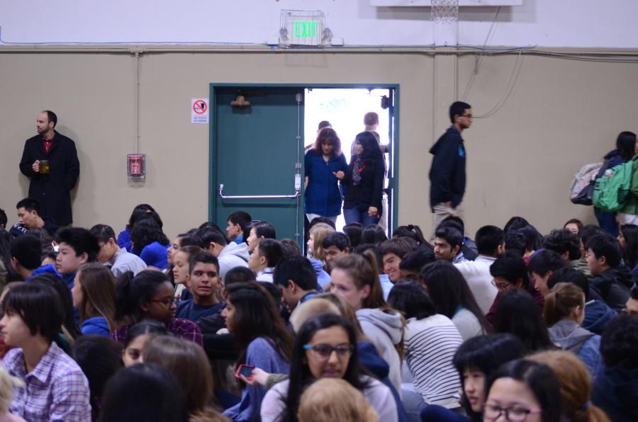 Students and teacher enter the gym for school meeting. 