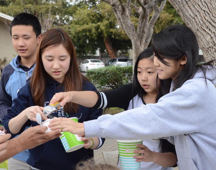  Sarah Tien (10) and and Haley Tran (10) work together in order to serve a customer outside of Manzanita after school. Some students who were not a part of Interact decided to volunteer and help sell Pinkberry to their peers as well.