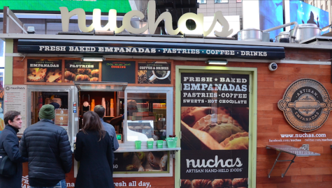 A group of New Yorkers wait in line to order at the Muchas Nuchas stand in Times Square. The stand sells everything from coffee and empanadas to croissants and hot chocolate.  