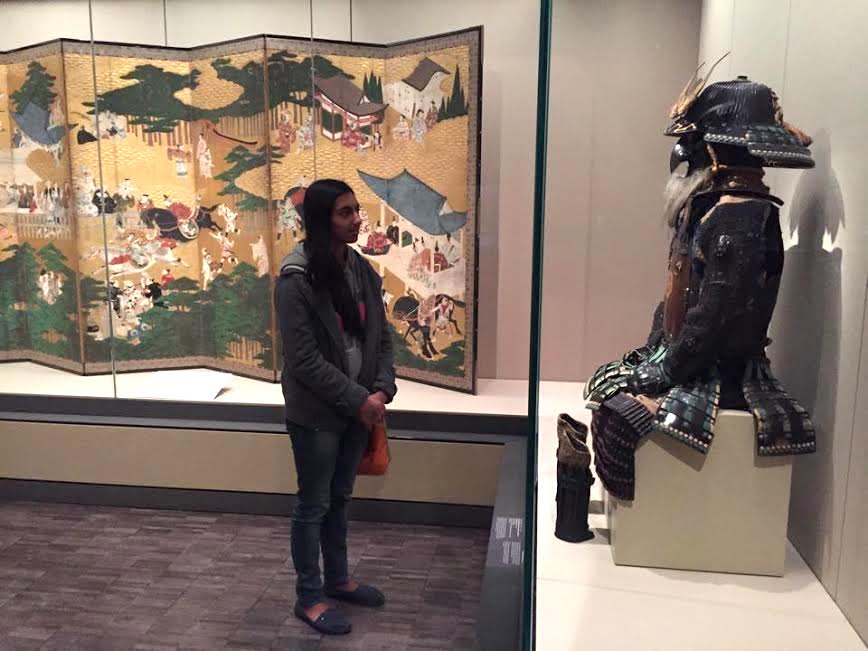 Senior Maya Nandakumar examines a piece of artwork from the Asian Art Museum of San Francisco. The AP Art History class visited the museum yesterday to prepare for a class project.