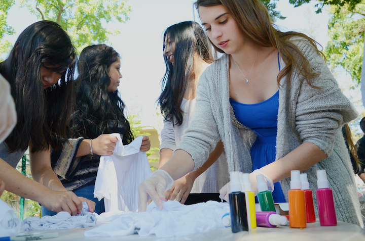 Katy Sanchez (12) ties her shirt with rubber bands before spraying paint on it. Spirit Club hosted the tie-dye event so that students could wear something on Tie Dye Day during Spirit Week.