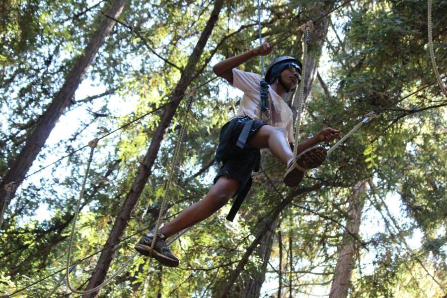 Matthew McCallaCreary (10) completes a ropes course activity by balancing himself to cross a tightrope. The sophomore class trip was held on Aug. 20. 