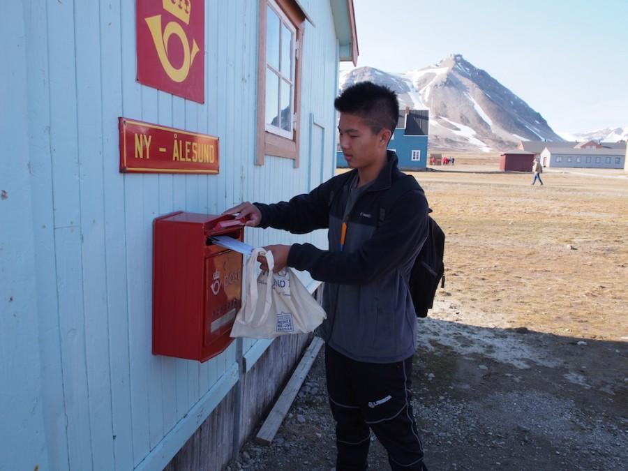 ARCTIC POST Edward Sheu (12) mails a letter from the northermost post office in the world. In July, 12 students embarked on an expedition to research the effects of climate change on the Arctic environment and habitat.