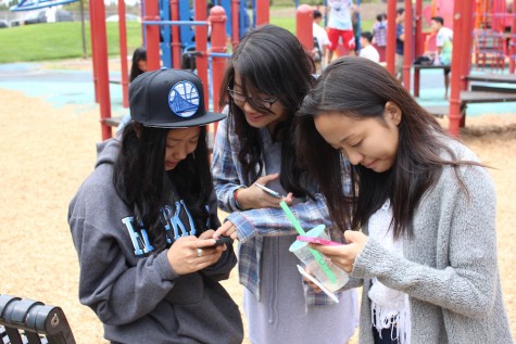 Sarah Tien (11), Haley Tran (11) and Kathy Duan (11) use their phones while waiting for their friends. The iPhone 6s and 6s+ come out in stores on Sept. 25.