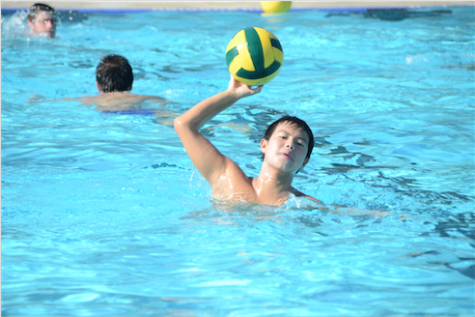 Andrew Chang (9) hits a water polo ball during summer practices for boys' water polo.