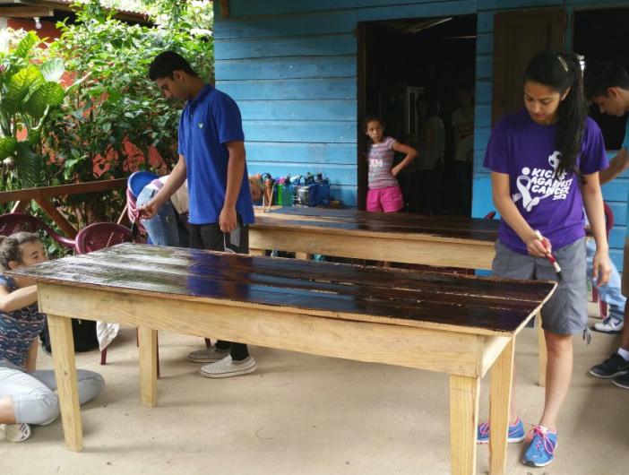 Natasha and other students on the trip add a coating to one of the tables at Los Mujeres del Plomo for protection against weather and insects. Natasha and 16 other high school students traveled to Nicaragua for three weeks over summer, participating in service projects and learning more about the area.