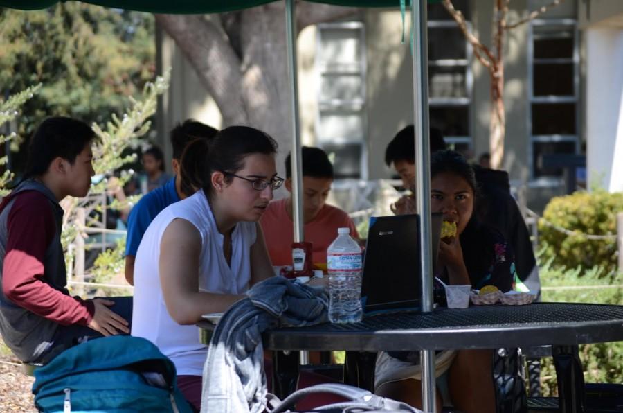 Students avoid the sun while eating lunch and studying by sitting in the shady area of the table. San Jose is experiencing a heat wave that will last throughout the week.