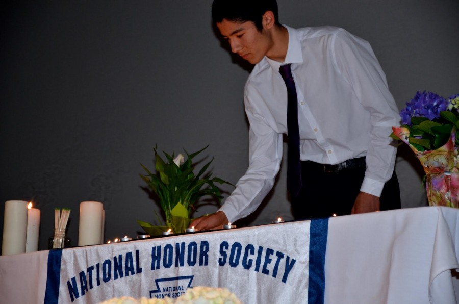 Sandip Nirmel (11) lights a candle as an initiation for NHS. The NHS officers and faculty held a ceremony yesterday to welcome the 30 new members to the organization.