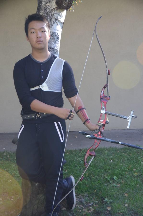 Linus Li (10) poses in his archery uniform alongside his bow outside of Main. [The bow] weighs about forty pounds, Linus said.