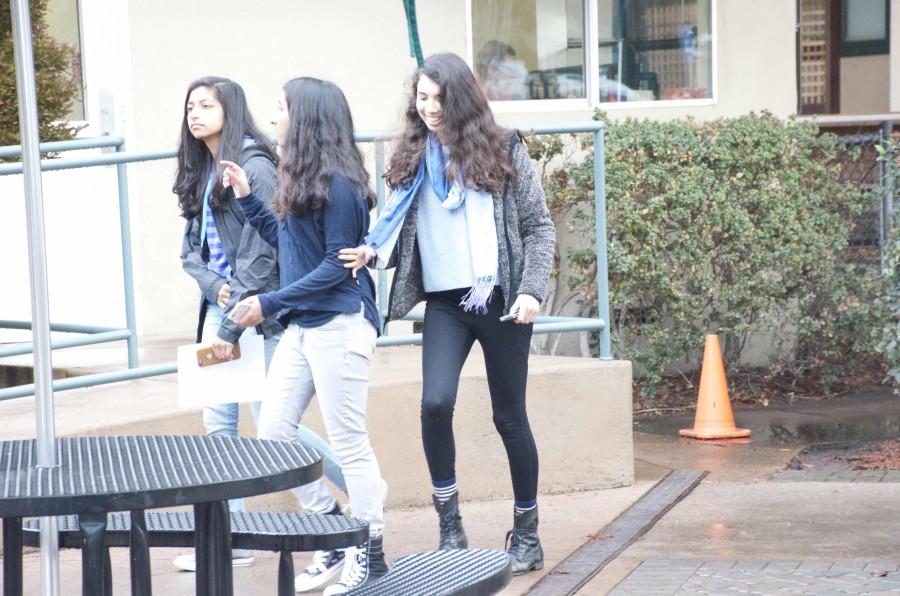 Wearing leggings, Sanjana Marcé (11) walks in the rain along with Trisha Dwivedi (11) and Kshithija Mulam (11). The new dress code was implemented on Nov. 31. 