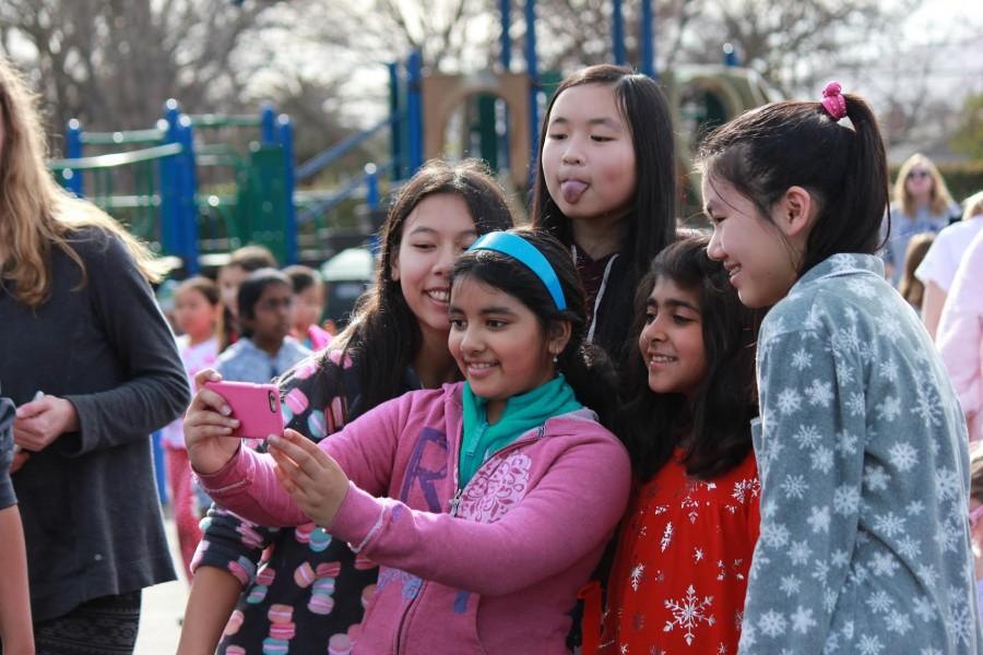 Charlotte Charley Huang (10), Jerrica Liao (10) and Jessica Wang (10) take a selfie with their Eagle Buddies. The sophomore class traveled to the lower school campus on Jan. 15 to meet with their Eagle Buddies at the culmination of the third grades service project to collect pajamas and books. 