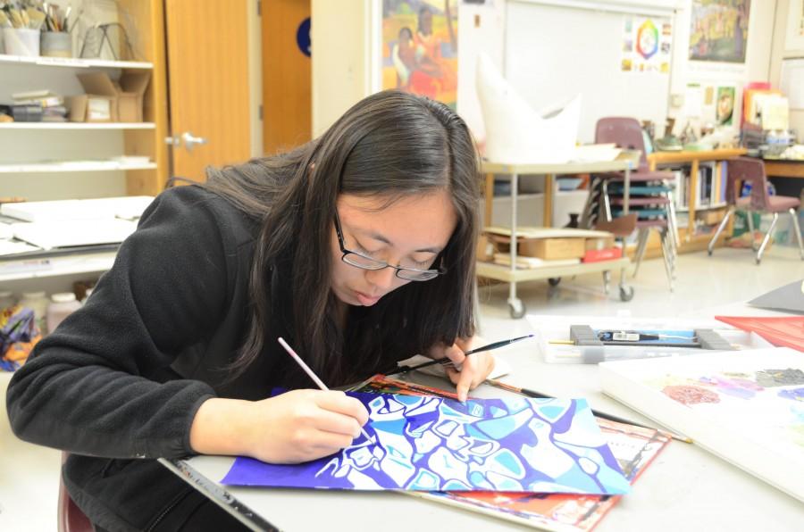Doreene Kang (12) works on a piece with acrylic paint in the art studio. The exhibition will take place next Wednesday during long lunch in the Nichols atrium. 
